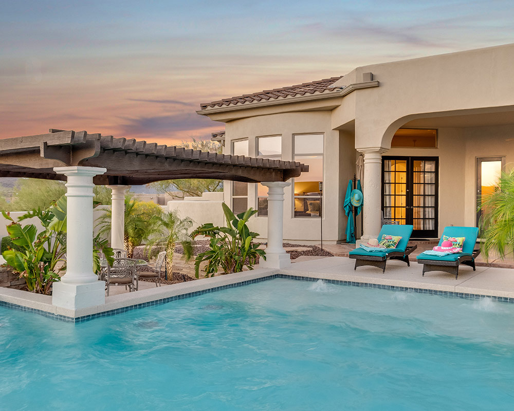 residential property backyard with swimming pool and sunset at the sky desert ridge az
